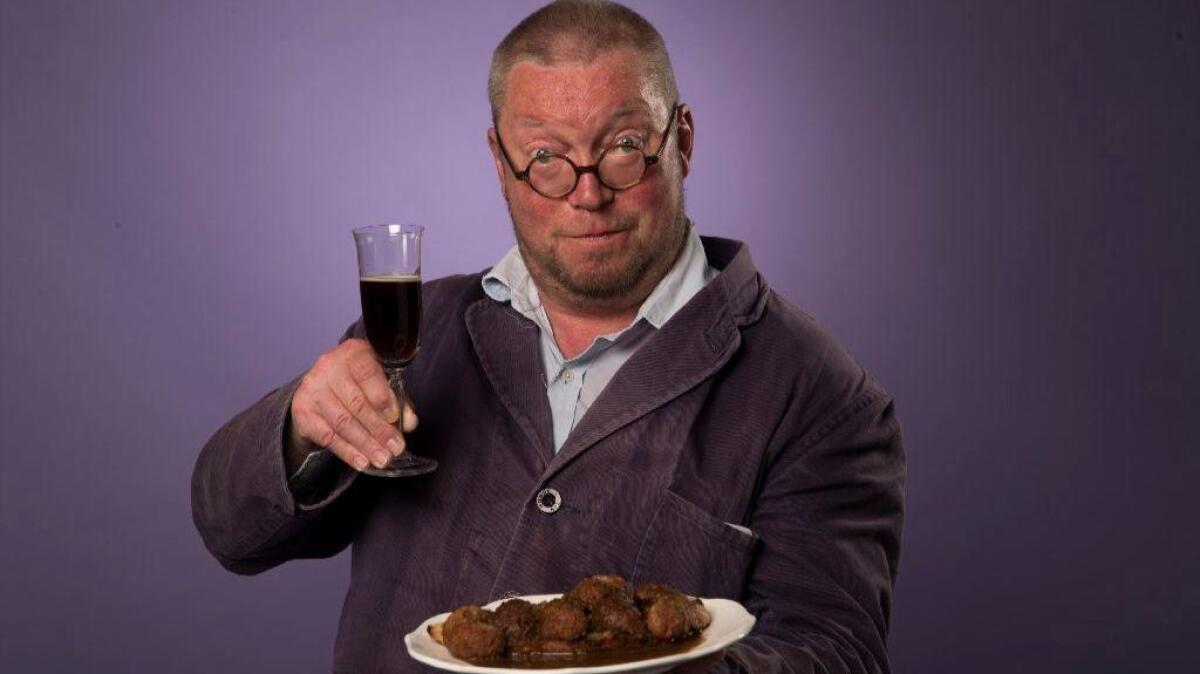 British chef Fergus Henderson holds a plate of deviled kidneys and a glass of Black Velvet.