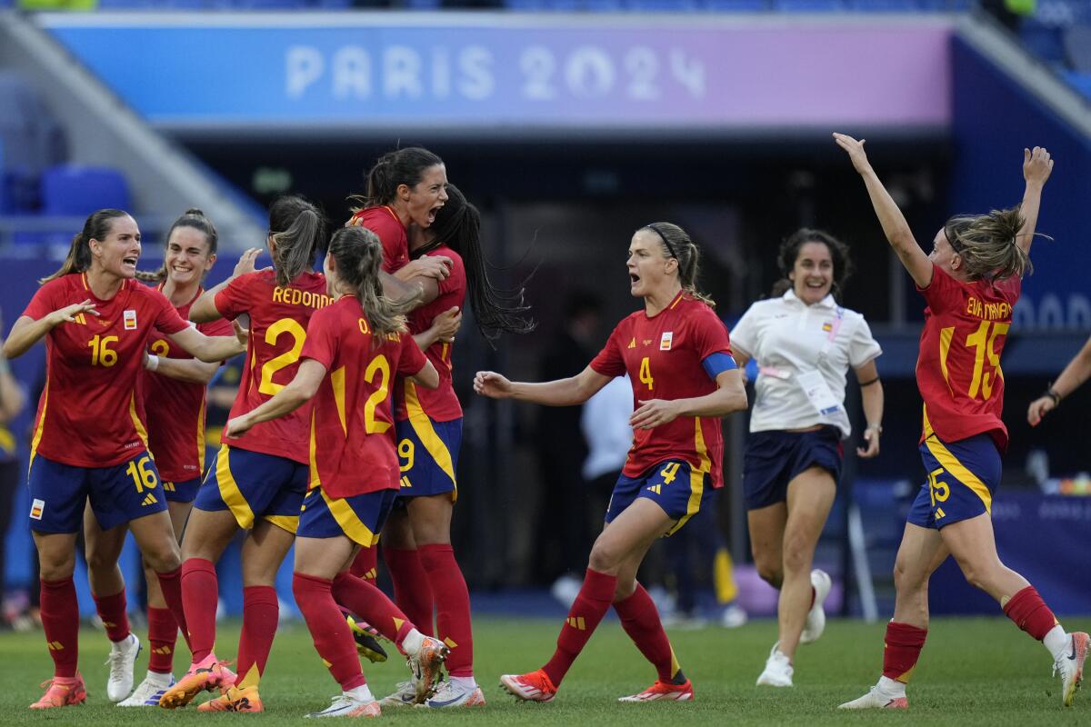 Spain players celebrate after defeating Colombia in a penalty shootout during the women's soccer quarterfinals 