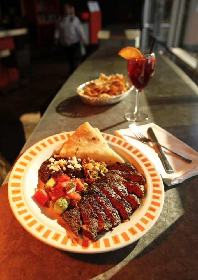 The grilled skirt steak is served with black beans and handmade tortillas.