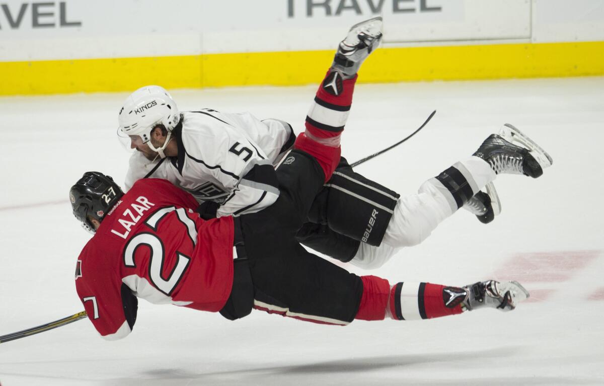Kings defenseman Jamie McBain (5) and Senators right wing Curtis Lazar collide during the second period.