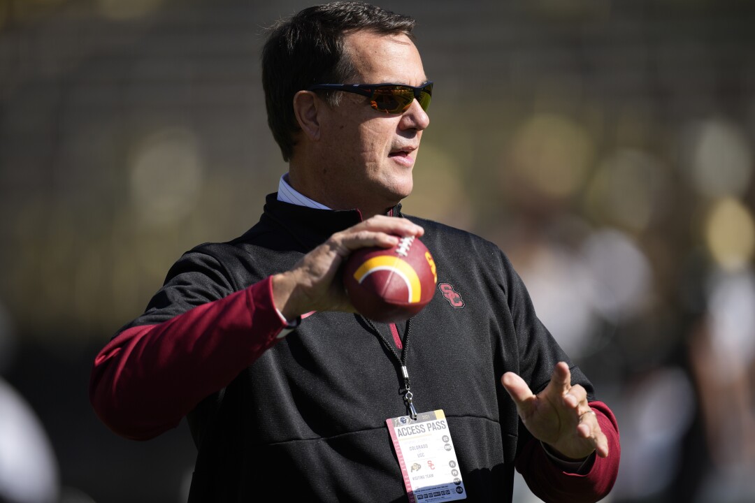 USC athletic director Mike Bohn tosses a football before the Trojans play Colorado on Oct. 2