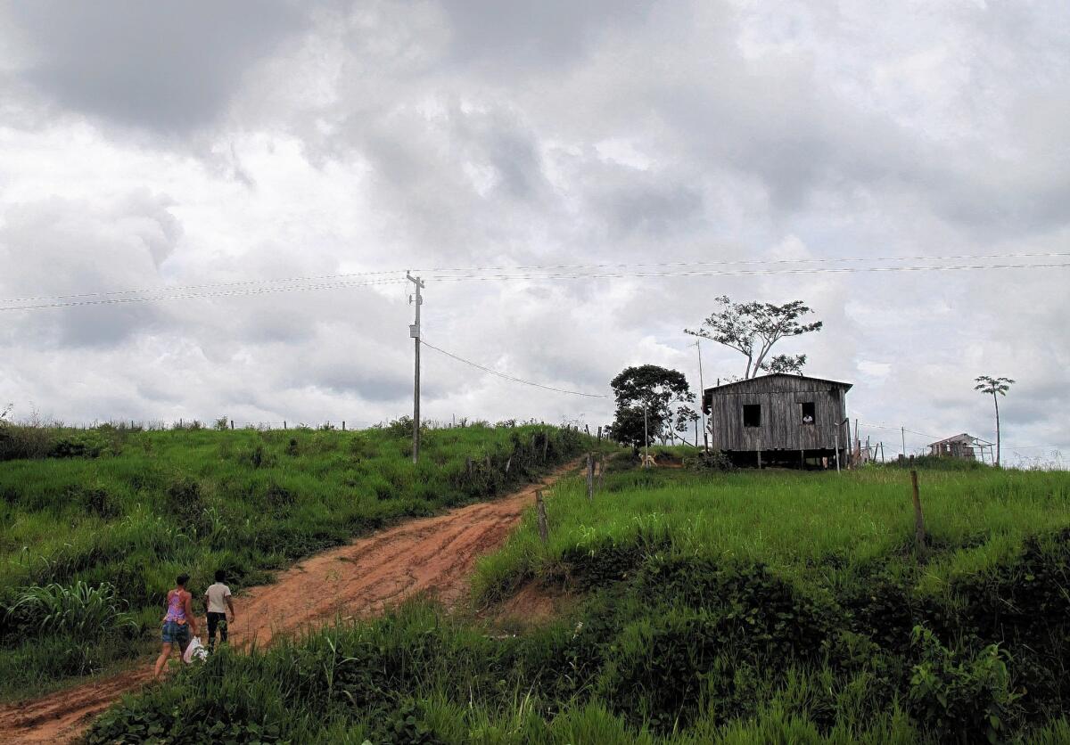 Eleven-year-old Vinicius and his mother walk to their home in the Rio Branco area of the deforested Amazon jungle after his visit with a Cuban doctor working in Brazil as part of the Mais Medicos program.
