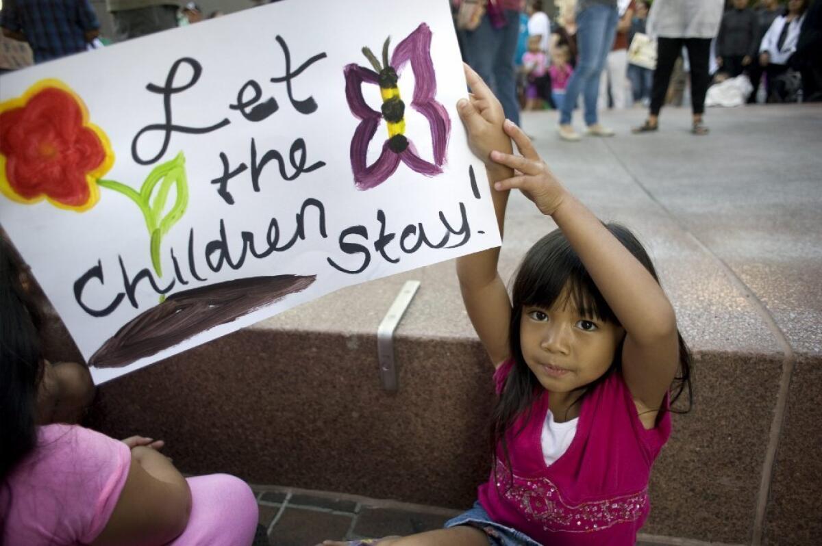 A child holds up a sign in support of migrant children at a demonstration last month in San Diego.