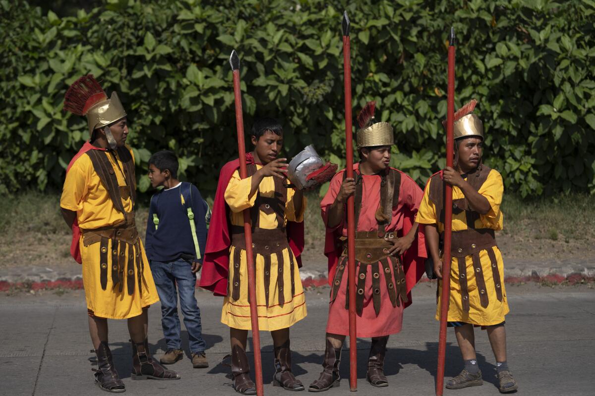 Fieles disfrazados de soldados romanos participan en una procesión