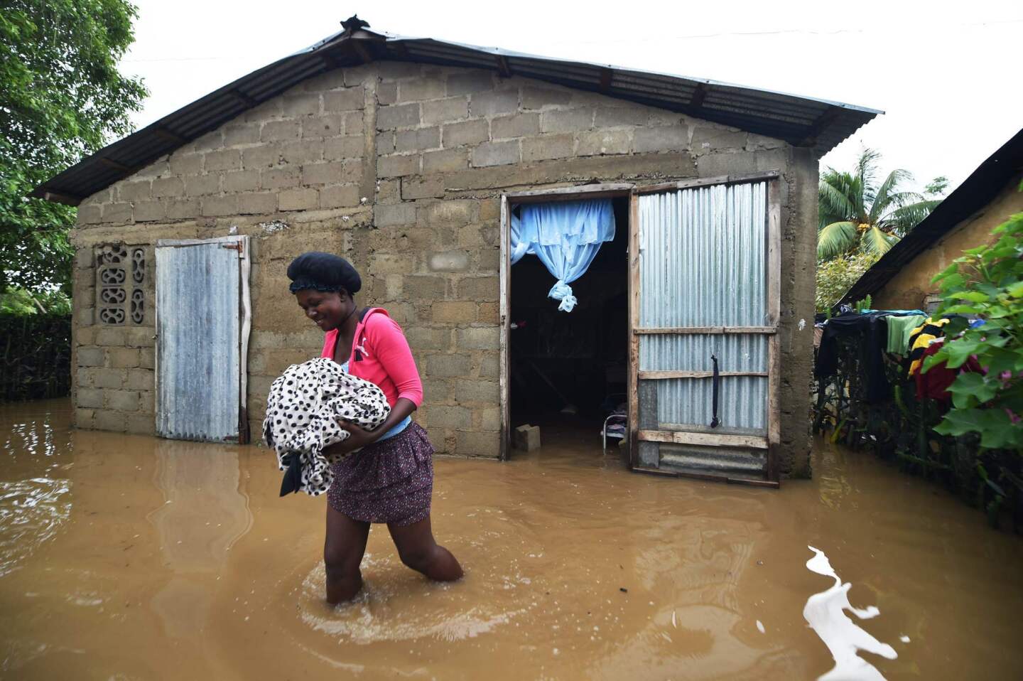Marie Charlotte walks through water near her house that was flooded, in the city of Fort Liberte, in the north east of Haiti, on September 8, 2017, after the passage of Hurricane Irma.