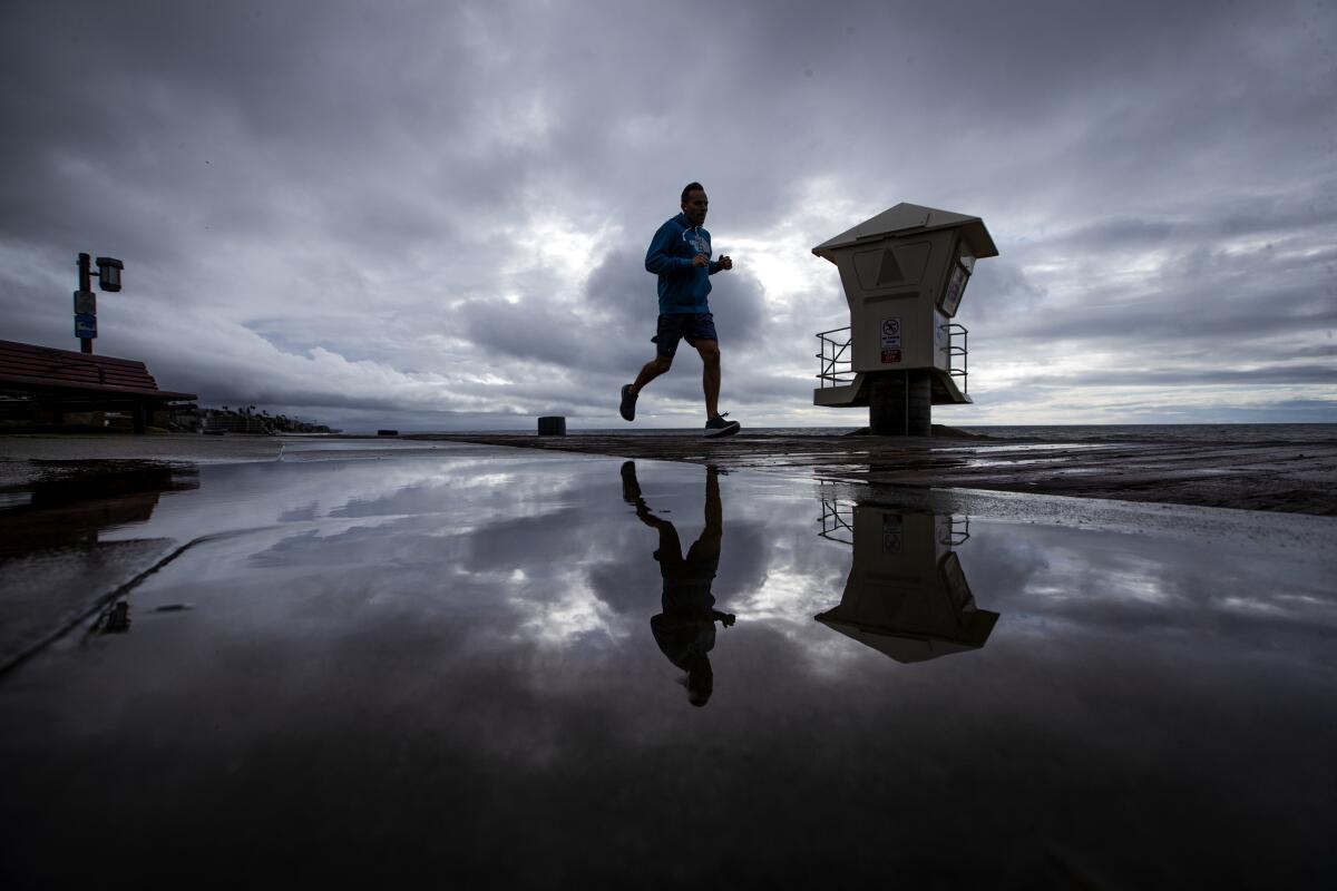 A man is reflected in a puddle at Main Beach in Laguna Beach this week.