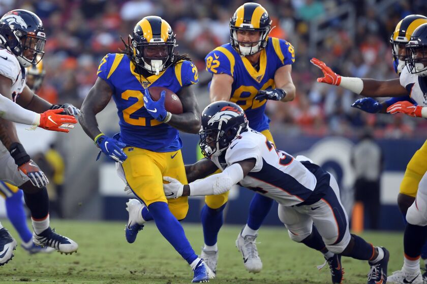 Los Angeles Rams running back Darrell Henderson, left, runs against the Denver Broncos during the first half of an NFL preseason football game Saturday, Aug. 24, 2019, in Los Angeles. (AP Photo/Mark J. Terrill)