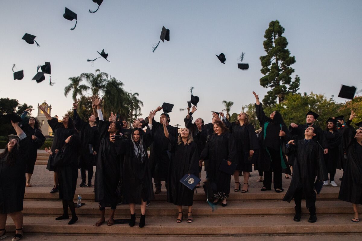 Graduating classes from 2019, 2020 and 2021 from the Library High School program throw their caps in the air.