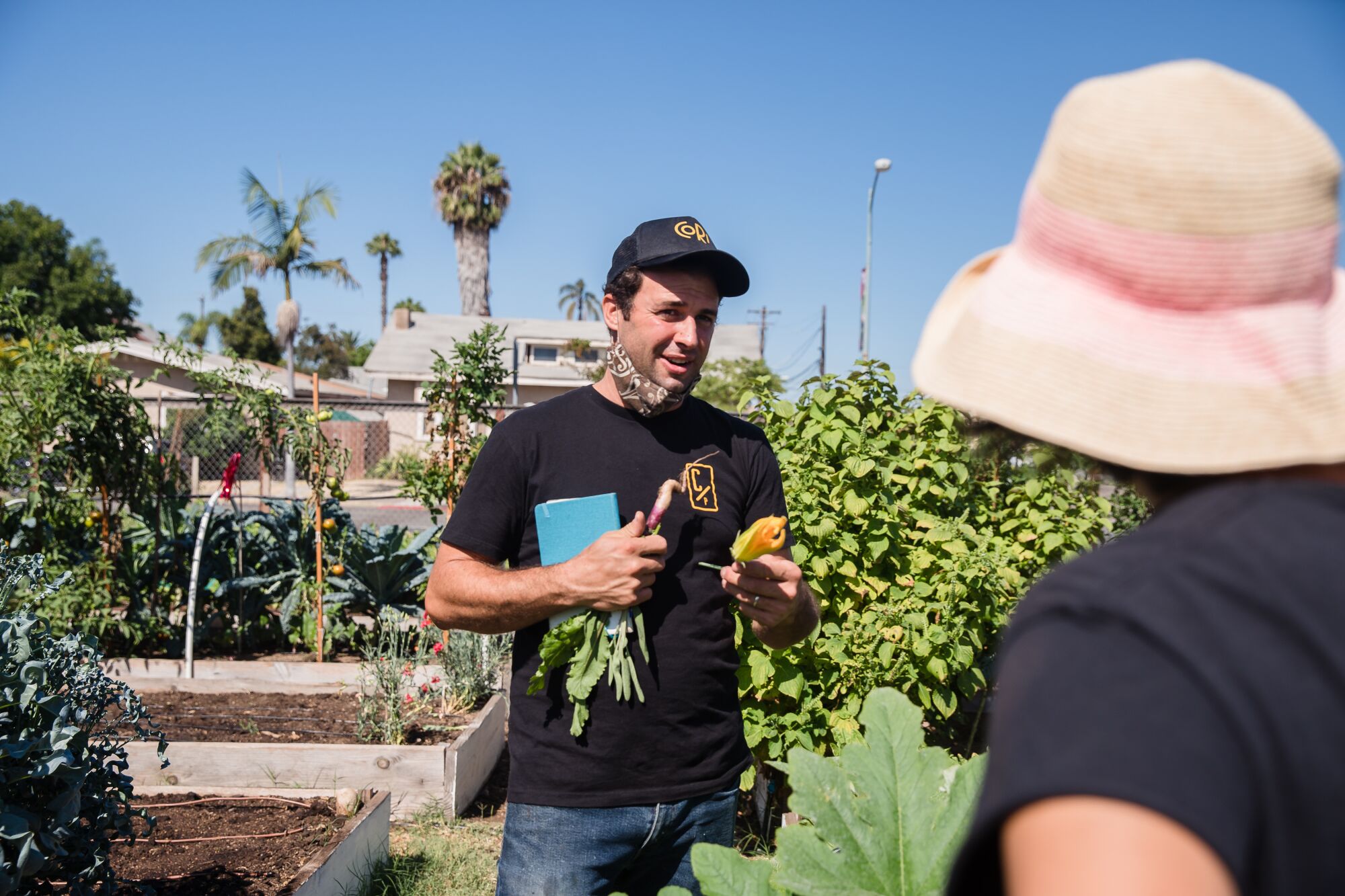 Accursio Lota, owner of Cori Pastificio Trattoria talks about the vegetables growing in the garden with Anchi Mei. 