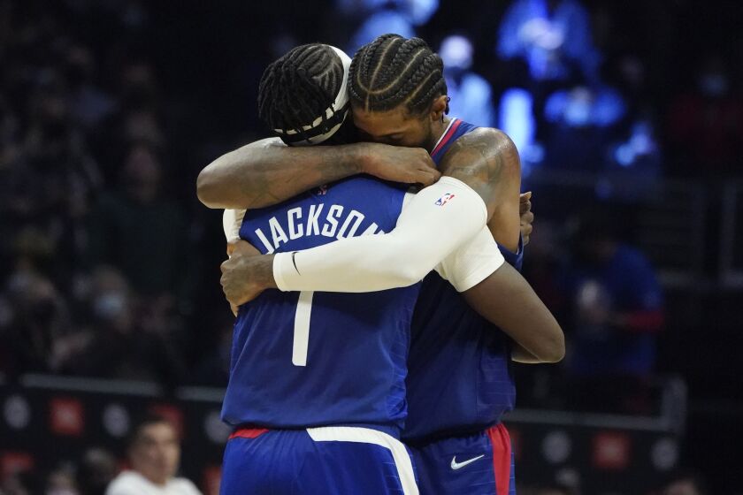 Clippers guard Reggie Jackson (1) gets a hug from close friend and teammate Paul George 