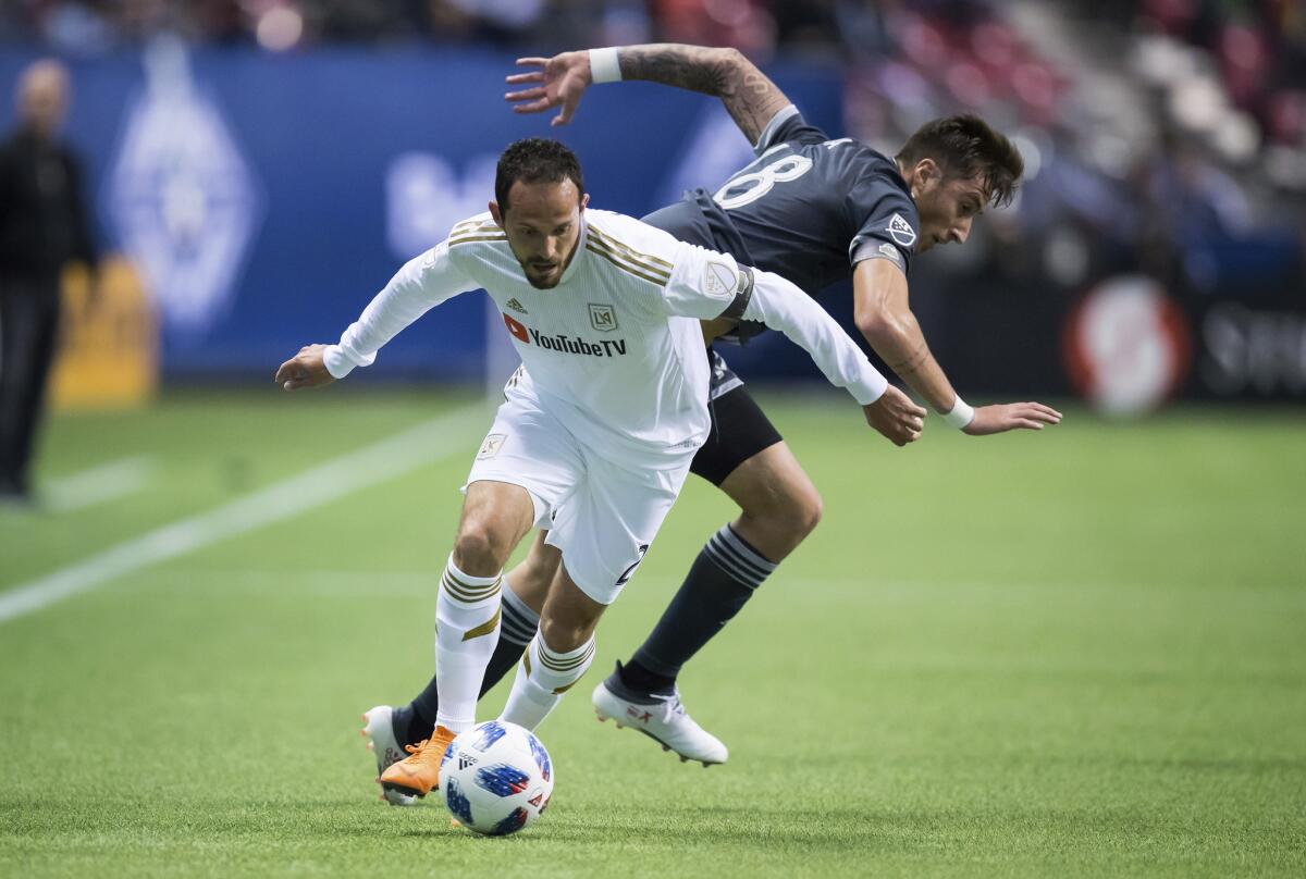 El delantero costarricense Marco Ureña (al frente) de Los Ángeles FC pugna por un balón con José Aja de Vancouver en un partido de la MLS, el viernes 13 de abril de 2018, en Vancouver, Canadá.
