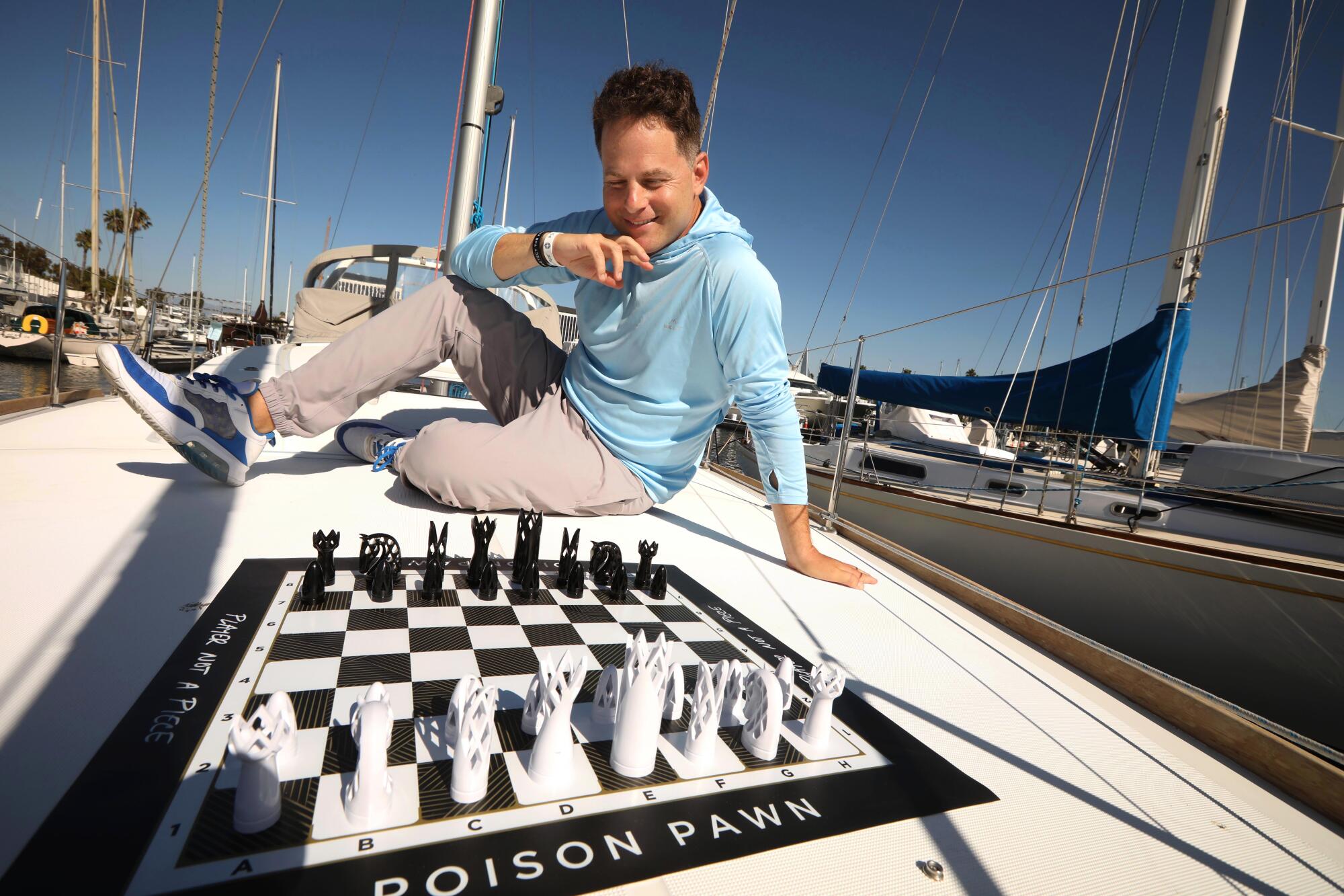 Chess master Seth Makowsky on his boat in Marina del Rey on October 5, 2023 with chess board on deck.