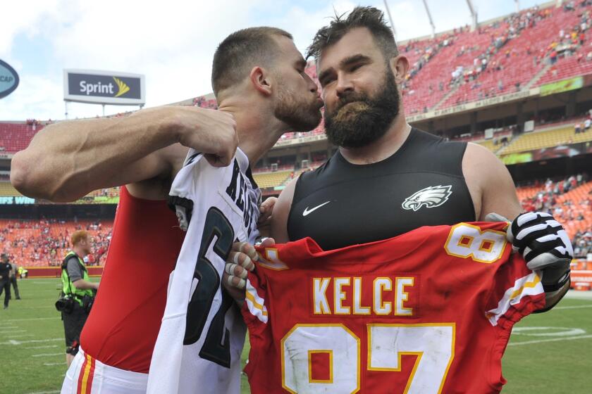 Chiefs tight end Travis Kelce, left, kisses his brother, Philadelphia Eagles center Jason Kelce, after they exchanged jerseys