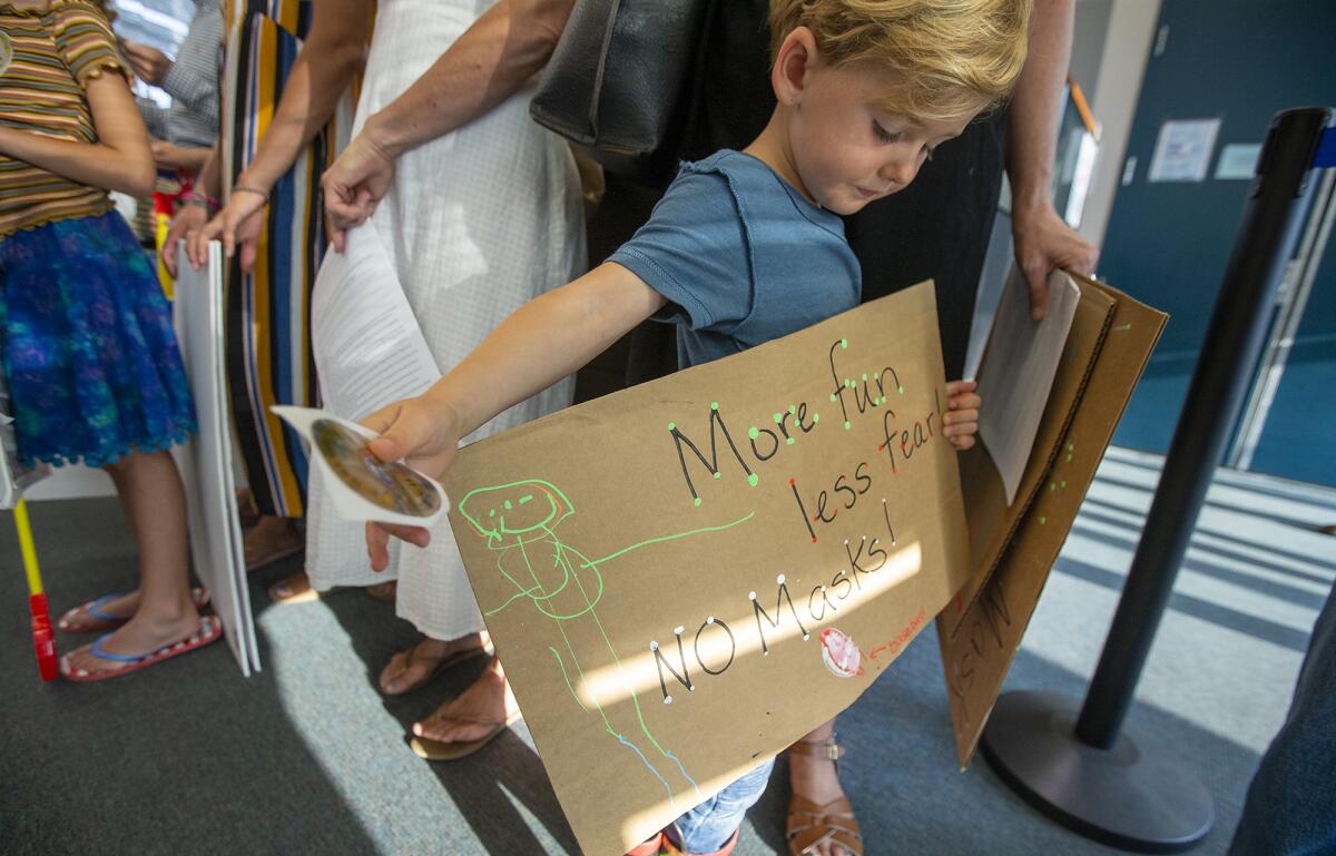 Ames Delle, 4, holds a sign during a "Let Them Breathe" rally at Newport Mesa Unified School District's office Aug. 17.