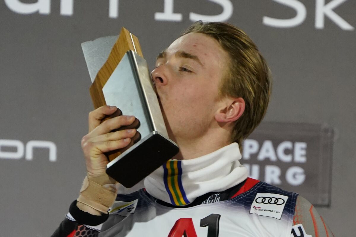 The winner Norway's Atle Lie McGrath celebrates on podium after completing an alpine ski, men's World Cup slalom race, in Flachau, Austria, Wednesday, March 9, 2022. (AP Photo/Piermarco Tacca)