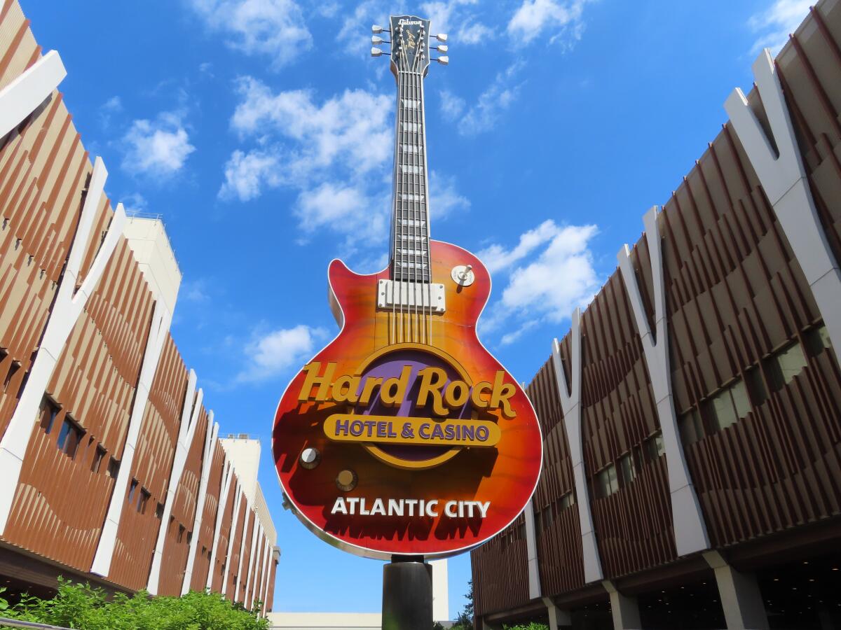 Clouds pass behind the guitar sculpture at the entrance to the Hard Rock casino in Atlantic City, N.J., on June 28, 2022. On Saturday, July 2, 2022, Hard Rock reached agreement with Atlantic City's main casino workers union, ending the last possibility of a strike during the busy July Fourth weekend. (AP Photo/Wayne Parry)