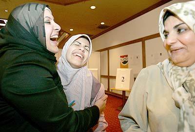 JOYOUS OCCASION: Iraqi expatriates Dalia Ridha, 22, left, and Marwa Sadik, 19, with her mother, Najah Mohamed, right, celebrate at the polling place at the former El Toro Marine Base in Irvine.