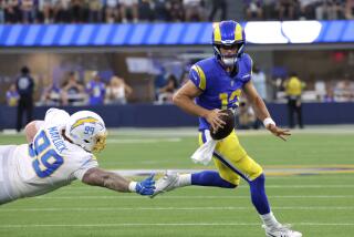 INGLEWOOD, CA - AUGUST 12: Rams quarterback Stetson Bennett scrambles away fron Chargers Scott Matlock.