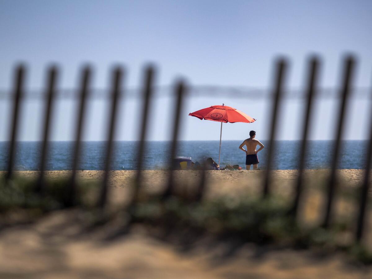 A beachgoer surveys the ocean July 2 at Bolsa Chica State Beach in Huntington Beach.