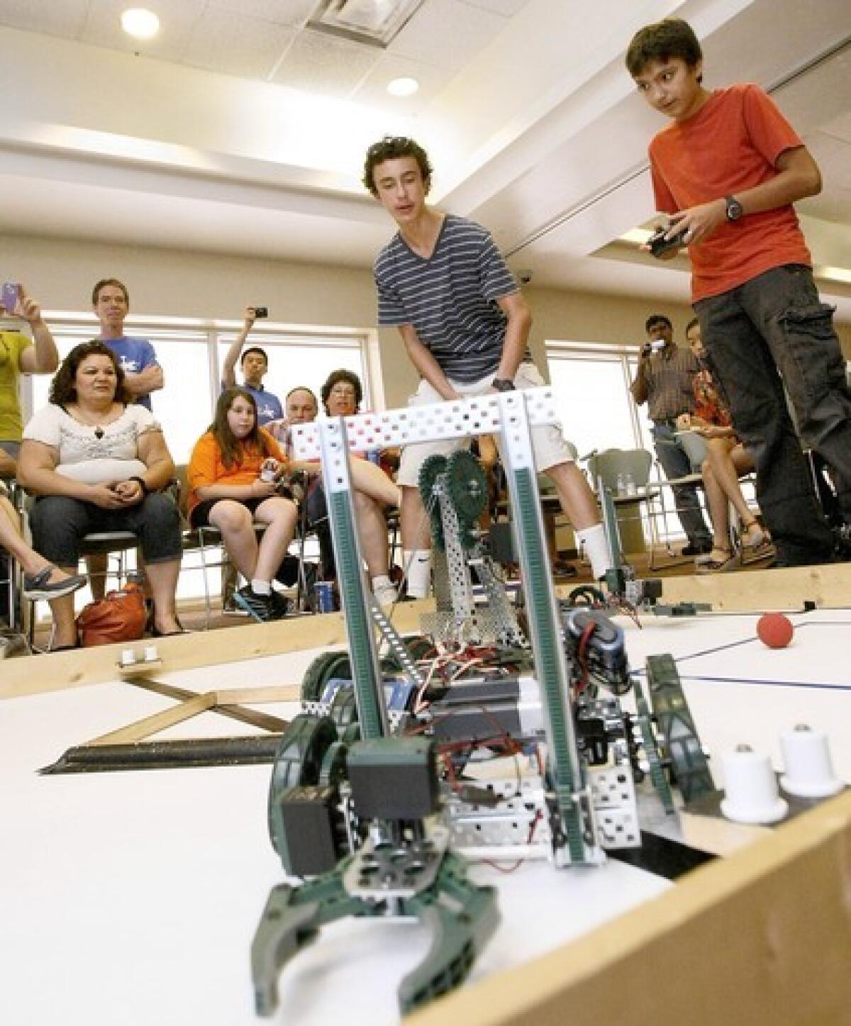 Clark Magnet High School student Alexander Luke, standing at left, works his remote controlled vehicle during Robotics Academy at Glendale Community College in Glendale on Thursday, June 27, 2013. Local students in 9th and 10th grade participated in the academy.