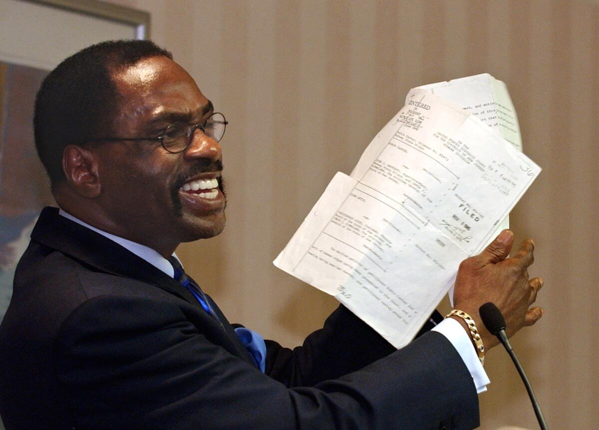 Rubin "Hurricane" Carter holds up the document that sealed his release from prison on a wrongful murder charge during a news conference held in Sacramento.