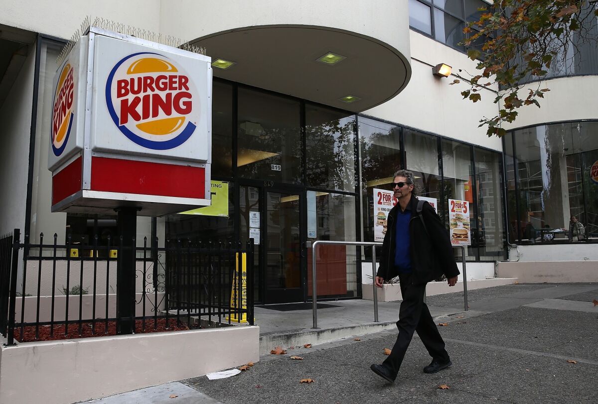 A pedestrian walks by a Burger King restaurant in San Francisco on Aug. 1.