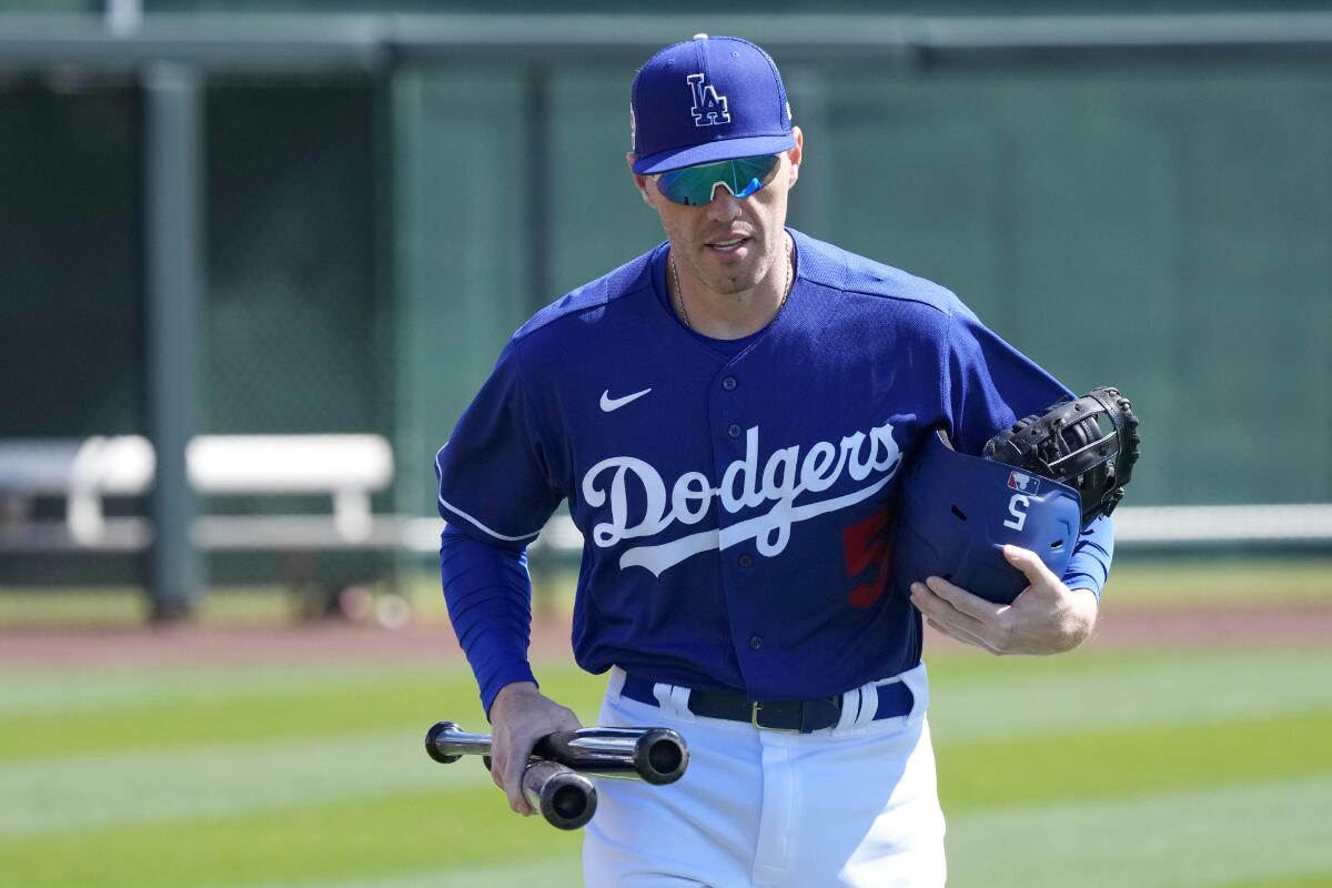 Dodgers first baseman Freddie Freeman runs to the dugout with his gear before a spring training game.