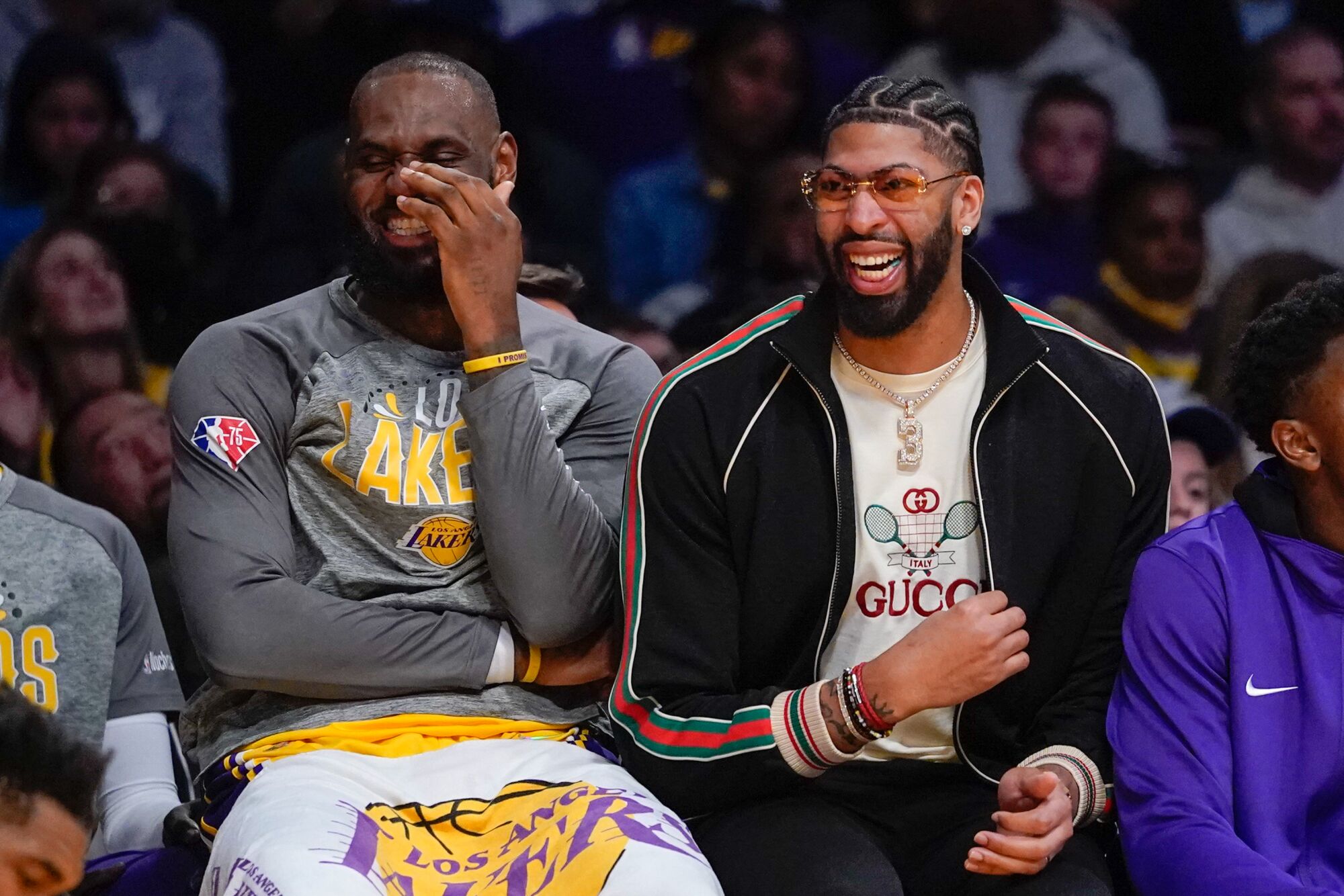Lakers forwards LeBron James, left, and Anthony Davis share a laugh while sitting on the bench.