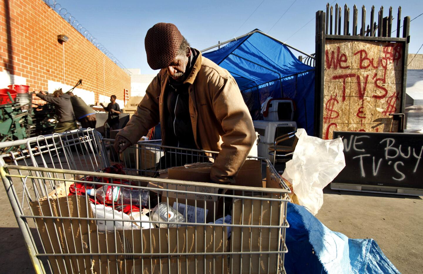 A man who goes by the name Double O sorts items he collected to recycle at West Coast Recycling at Towne Avenue and East 4th Street in downtown Los Angeles. Double O complained about a state law that took effect Nov. 1 reducing how much money he can get for wine, liquor and milk bottles.
