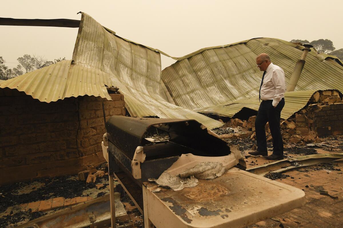 Australian Prime Minister Scott Morrison tours a fire-devastated farm in Sarsfield, Australia, on Friday.