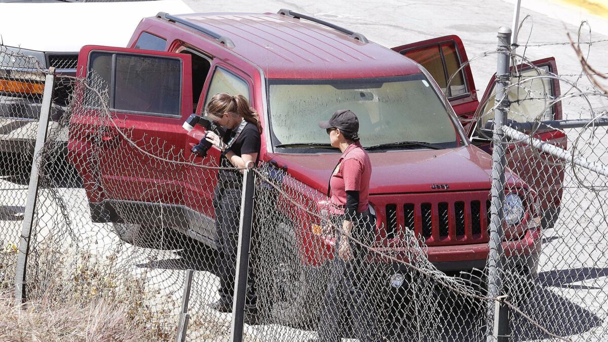 Police investigators examine the scene on South Varney Street near Linden Court in Burbank where three bodies were found in a burgundy Jeep Patriot.