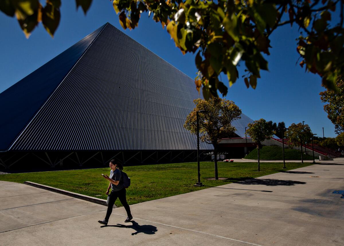 A student passes by the Walter Pyramid at Cal State Long Beach.