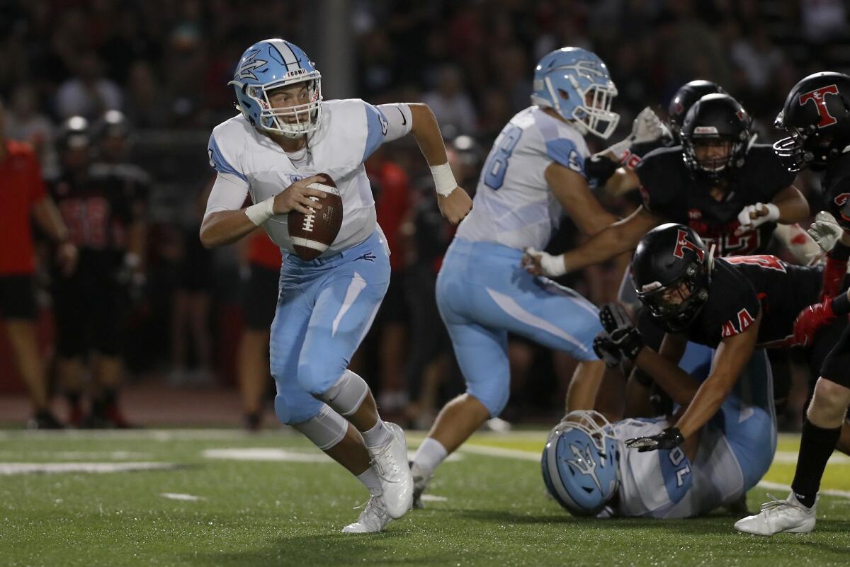 Corona del Mar High quarterback Ethan Garbers scrambles out of the pocket in the first half of a nonleague game at San Clemente on Sept. 14, 2018.