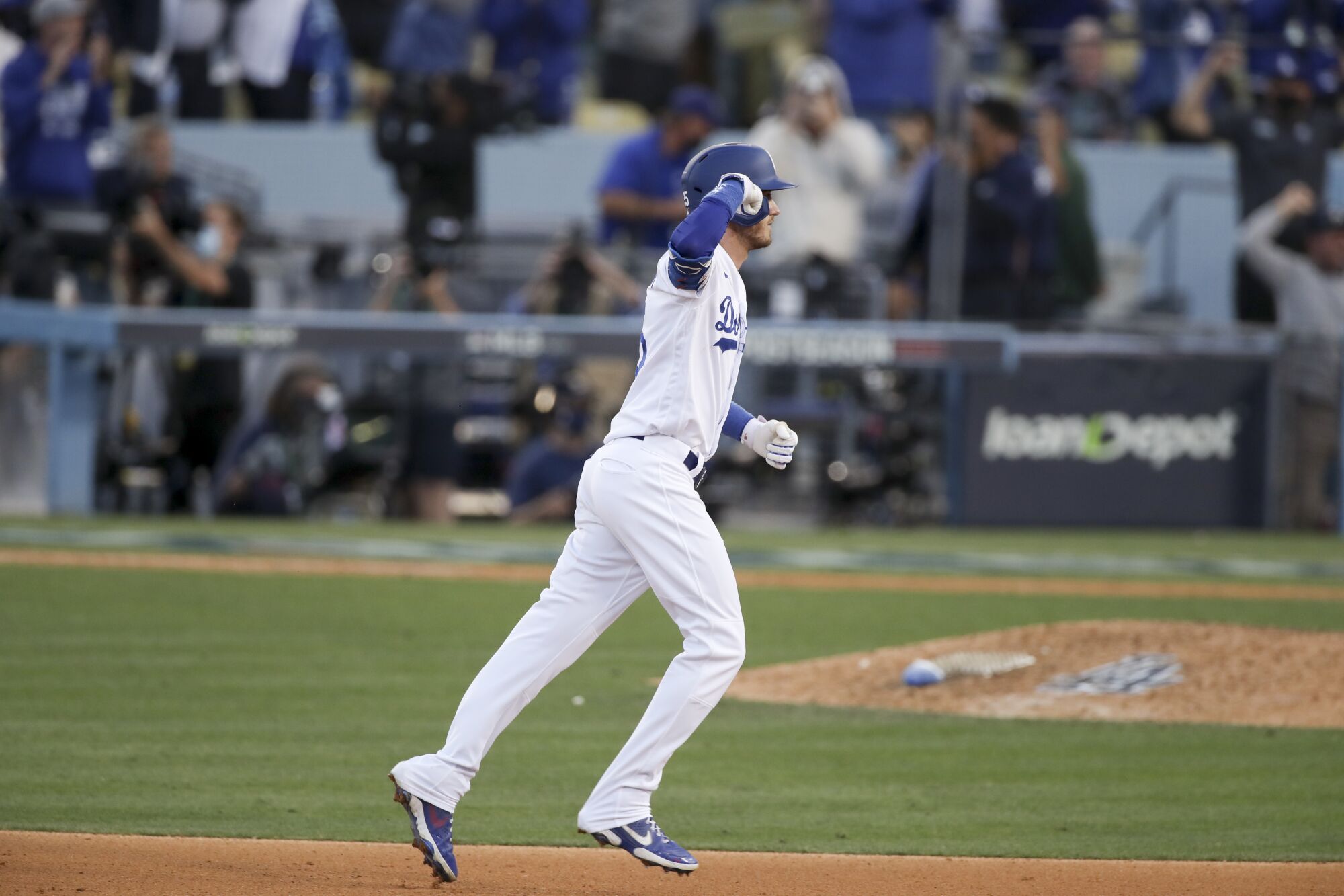 Los Angeles Dodgers' Cody Bellinger celebrates while rounding the bases after hitting the game-tying three-run home run.