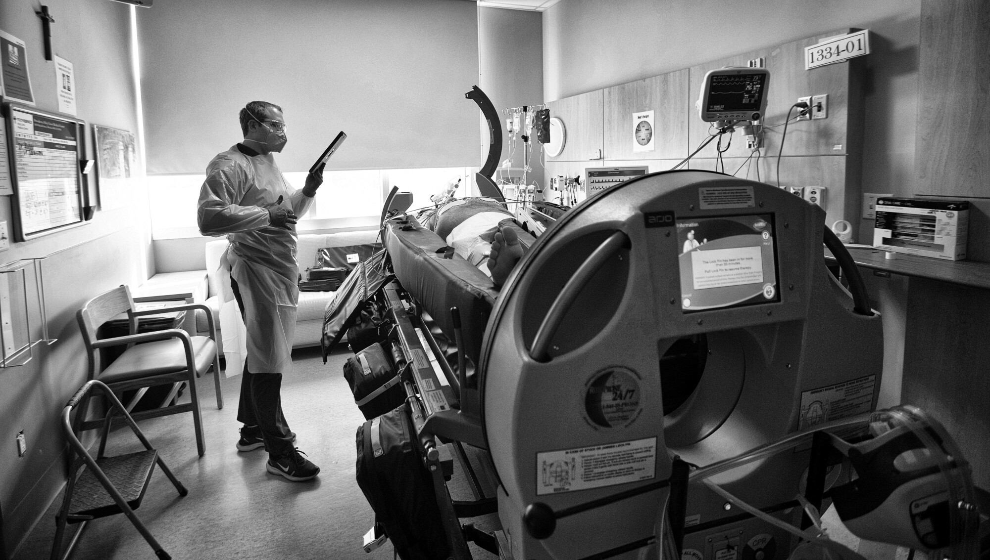 The fight against COVID, a chaplain says, unfolded on 'sacred ground' 9 A man holding an iPad for a man lying on hospital equipment