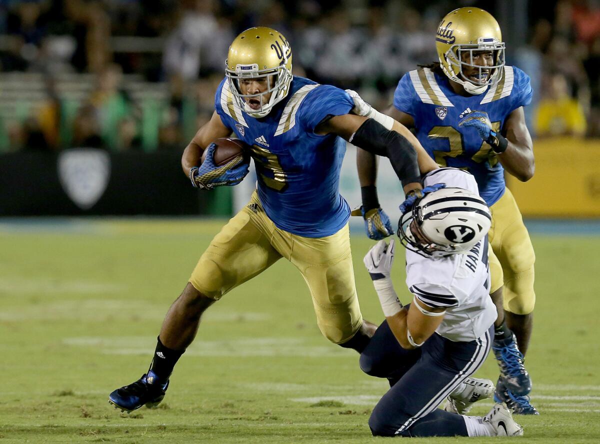 UCLA receiver Jordan Payton tries to elude BYU cornerback Micah Hannemann after making a catch in the second quarter Saturday at the Rose Bowl.