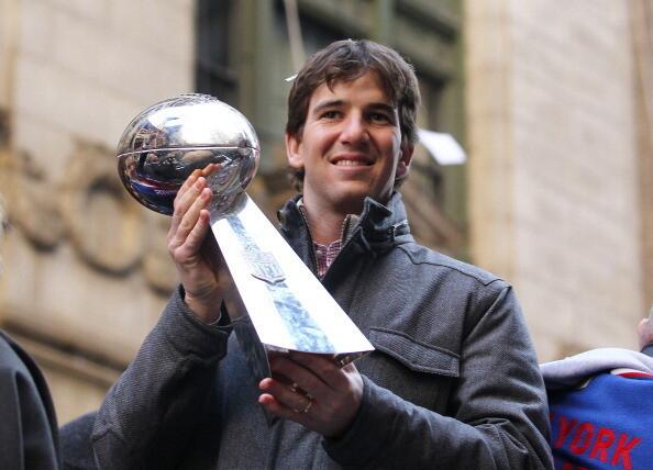 Eli Manning of the New York Giants holds the Vince Lombardi Trophy during the New York Giants' ticker tape victory parade down the Canyon of Heros on February 7, 2012 in New York City.