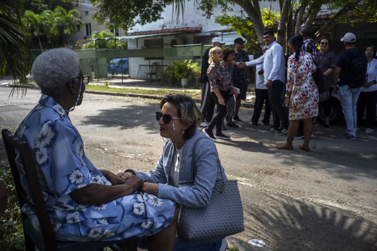 Congressional candidate Denisse Ricardo greets constituent Enidian Waugh, left, during a campaign tour in Havana, Cuba, Tuesday, March 21, 2023. Some eight million Cubans will vote on Sunday, March 26, for the deputies that will make up the People's Power National Assembly, a unicameral parliament. (AP Photo/Ramon Espinosa)