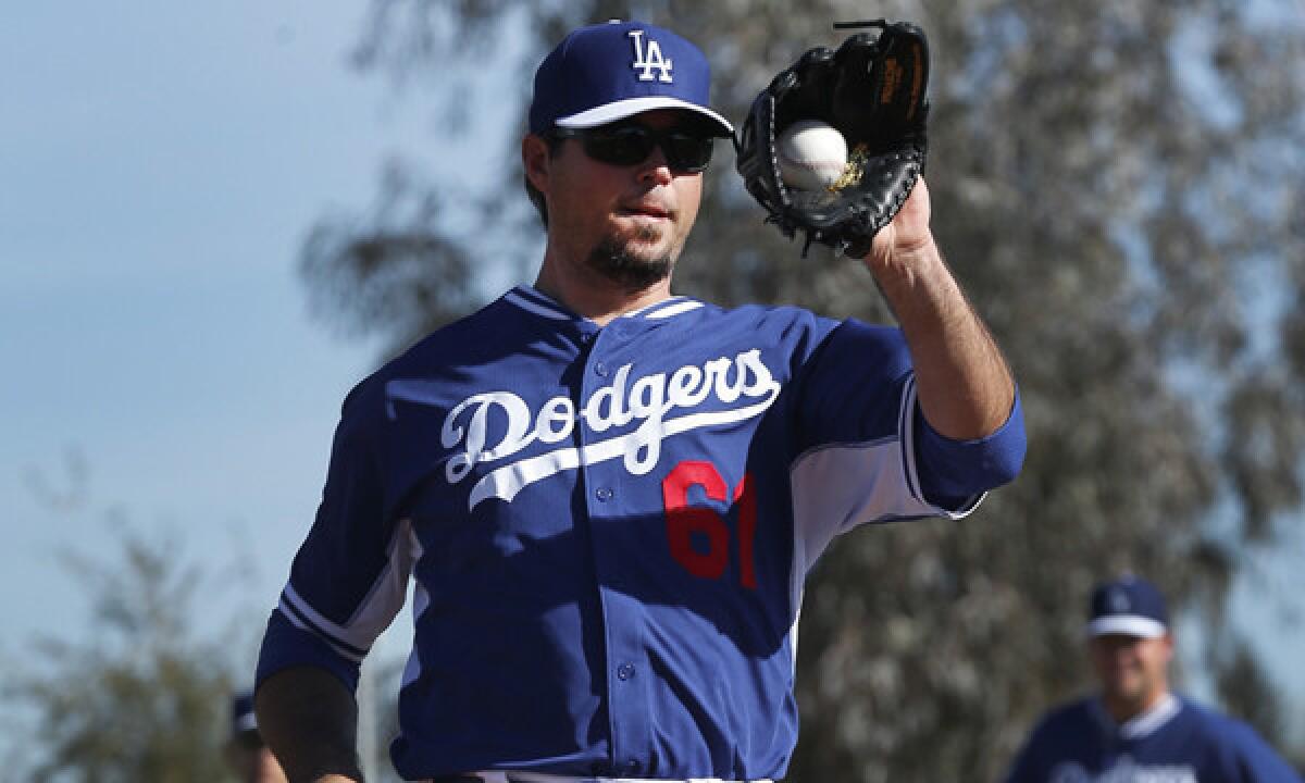 Dodgers pitcher Josh Beckett makes a catch during a spring training practice session Feb. 11. Beckett struggled in his Cactus League outing against the Seattle Mariners on Saturday.