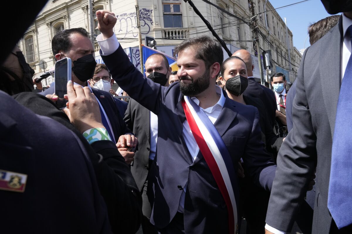 Chile's new President Gabriel Boric smiles and raises his fist