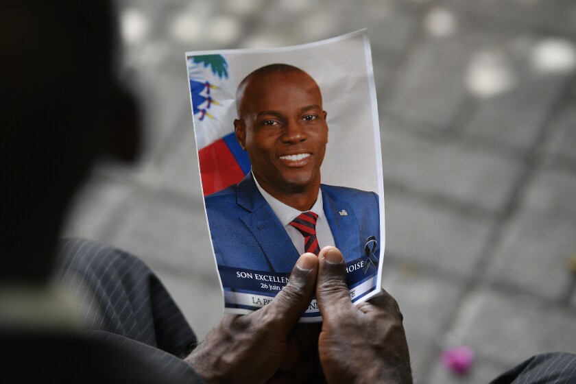 FILE - A person holds a photo of the late Haitian President Jovenel Moise during his memorial ceremony at the National Pantheon Museum in Port-au-Prince, Haiti, July 20, 2021. Haiti's National Police said Saturday, Jan. 15, 2022, that former Sen. John Joel Joseph, sought in the July 7 killing of Moise, has been arrested in Jamaica. (AP Photo/Matias Delacroix)