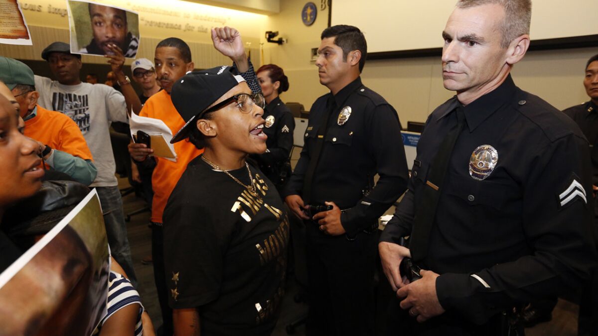 Protesters chant during an L.A. Police Commission meeting on Tuesday. The meeting, held on the first anniversary of the shooting death of South L.A. resident Ezell Ford, had to be halted briefly.