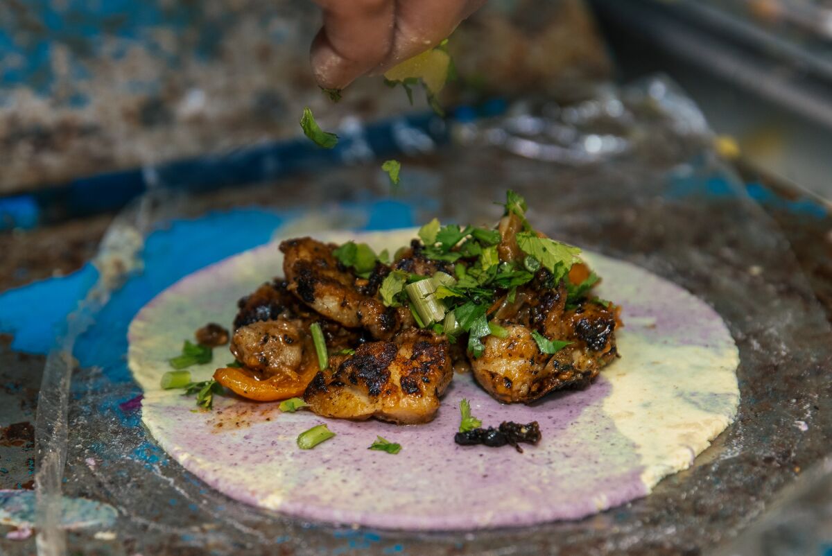 A Pescadilla taco gets a topping of cilantro at the Simón food truck.