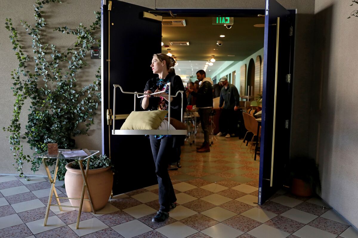 A shopper carries out a table, pillow and other items purchased at the Wing women's club in West Hollywood.