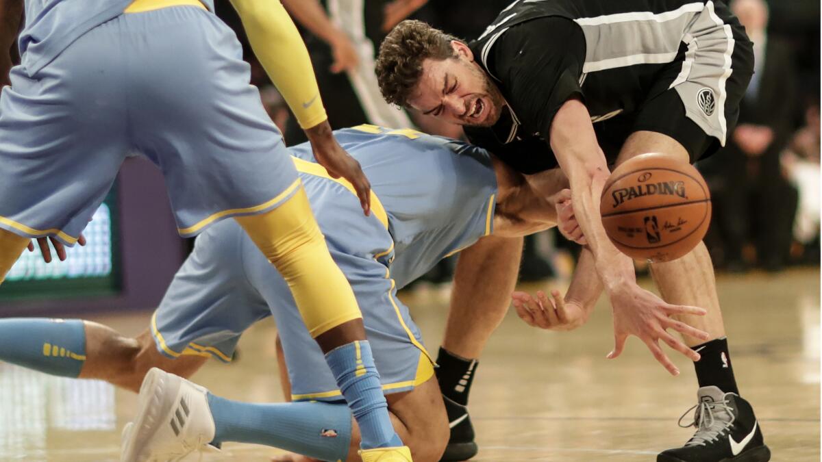 Spurs center Pau Gasol loses control of the ball as Lakers center Brook Lopez knocks it away during first-half action.