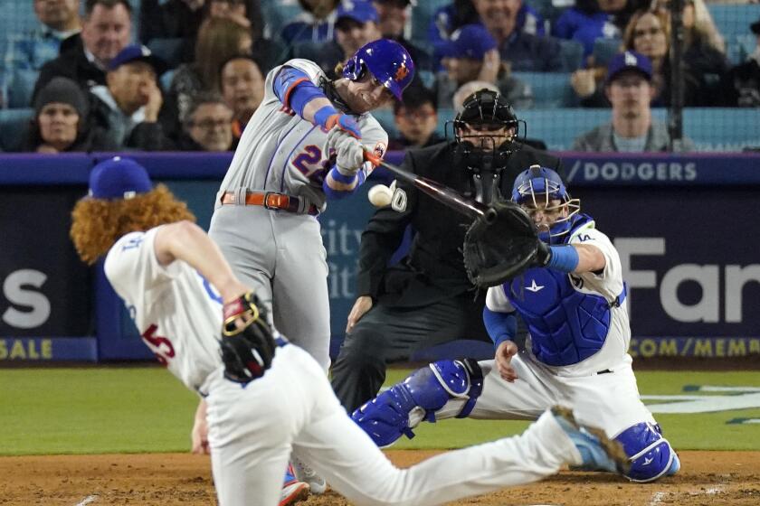 New York Mets' Brett Baty, second from left, hits an RBI single as Los Angeles Dodgers starting pitcher Dustin May, left, and catcher Austin Wynns, right, watch along with home plate umpire Mark Ripperger during the fourth inning of a baseball game Monday, April 17, 2023, in Los Angeles. (AP Photo/Mark J. Terrill)