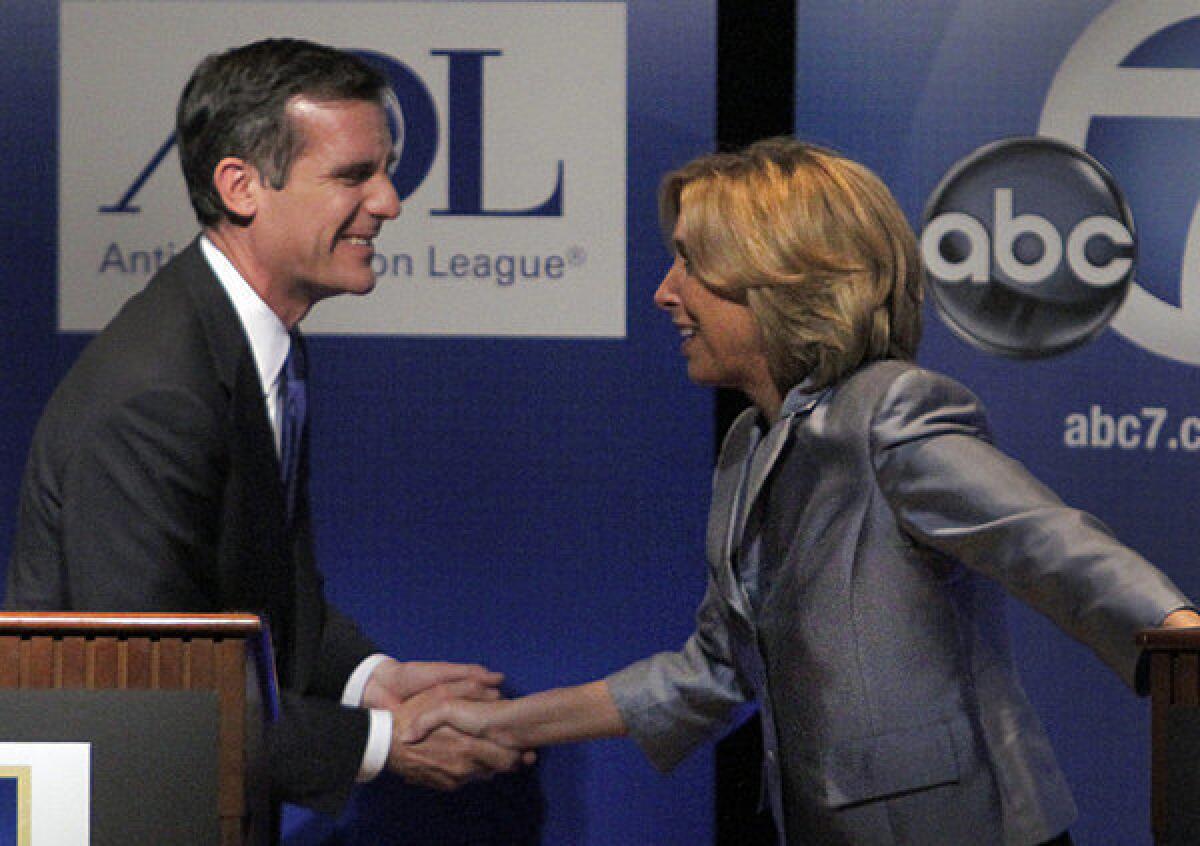 Mayoral candidates Eric Garcetti and Wendy Greuel shake hands after a debate.