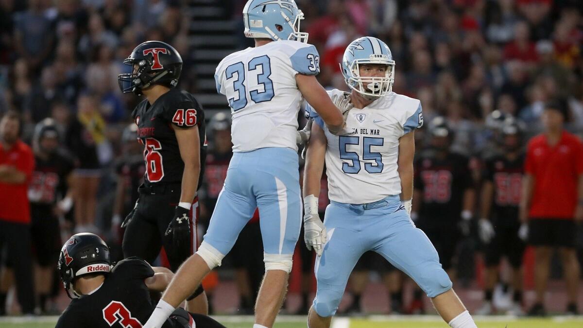 Corona del Mar High's Ethan Jajonie (55) celebrates with JJ Rottler (33) after sacking San Clemente's Brendan Costello (3) in the first quarter on Friday.