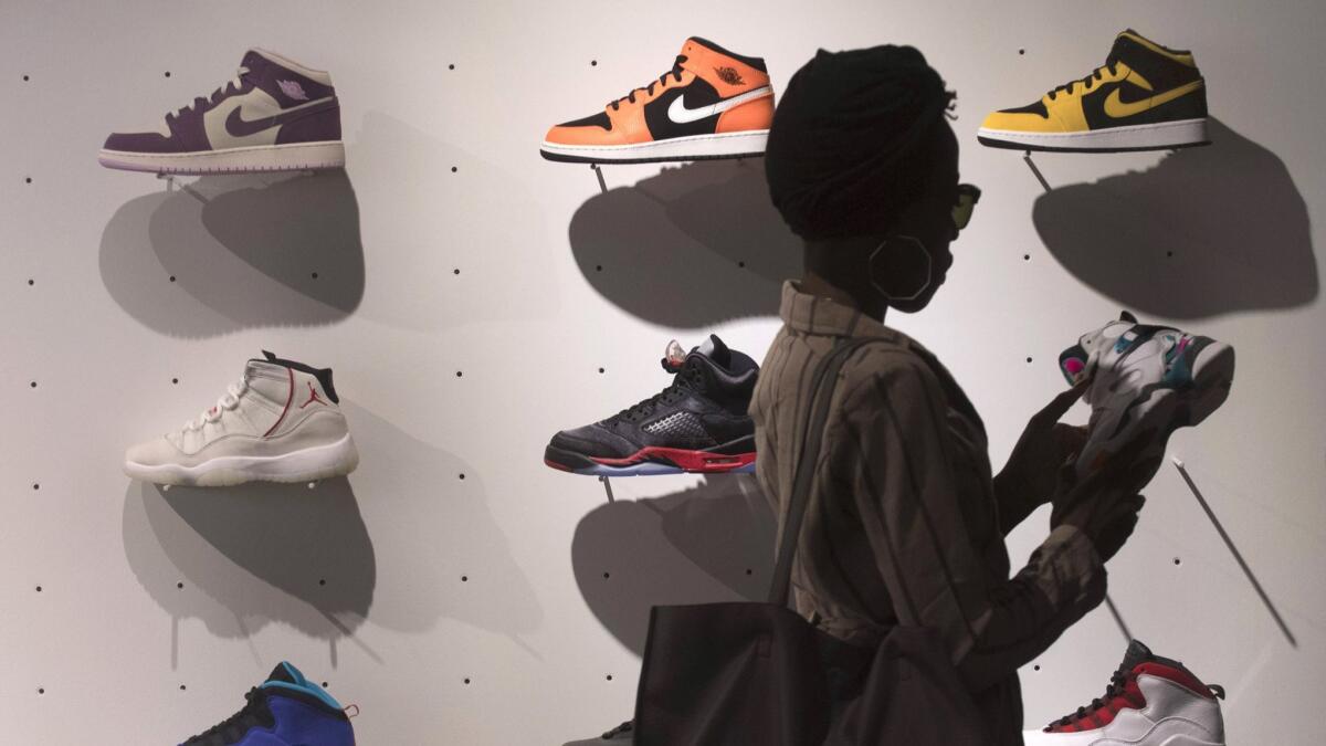 The explosive popularity of basketball sneakers and the rise of resale websites have turned shoes into an asset that can be sold like Wall Street securities. Here, a shopper examines a wall of Nikes at the Jumpman LA store in downtown Los Angeles.