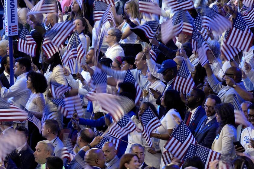 Attendees wave American flags during the Democratic National Convention Thursday, Aug. 22, 2024, in Chicago. (AP Photo/J. Scott Applewhite)